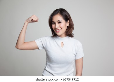 Beautiful Young Asian Woman Flex Bicep On Gray Background