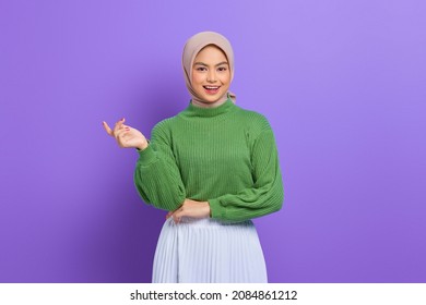 Beautiful young Asian woman in green sweater smiling happy and looking confident isolated over purple background - Powered by Shutterstock