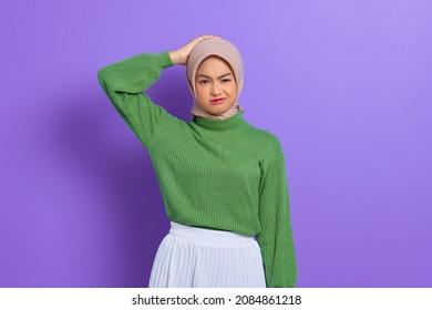 Beautiful young Asian woman in green sweater confused about a question, thinking with hand on head isolated over purple background - Powered by Shutterstock