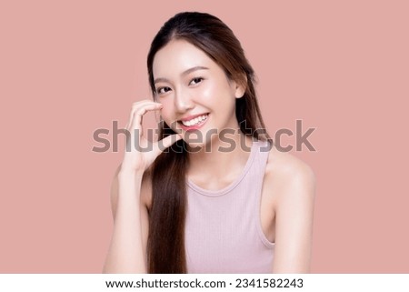 Beautiful young Asian woman with healthy and perfect skin on isolated pink background. Facial and skin care concept for commercial advertising.