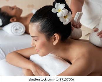 Beautiful Young Asian Woman Lying Relaxing And Smile On The Bed Having A Massage With Herbal Compresses In A Spa. Thai Massage For Health.  Select Focus Face Women