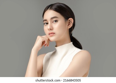 Beautiful young Asian woman model touch her face with perfect clean fresh skin on grey background. Face care, Facial treatment, Cosmetology, Plastic Surgery, Lovely girl portrait in studio.
