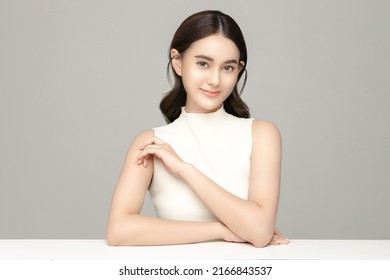 Beautiful Young Asian Woman Model With Perfect Clean Fresh Skin On Grey Background. Face Care, Facial Treatment, Cosmetology, Plastic Surgery, Lovely Girl Portrait In Studio.