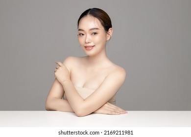 Beautiful Young Asian Woman Model With Perfect Clean Fresh Skin On Grey Background. Face Care, Facial Treatment, Cosmetology, Plastic Surgery, Lovely Girl Portrait In Studio.