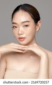 Beautiful young Asian woman model with perfect clean fresh skin on grey background. Face care, Facial treatment, Cosmetology, Plastic Surgery, Lovely girl portrait in studio.