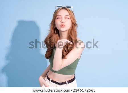 Beautiful young Asian woman on blue background, summer vacation concept