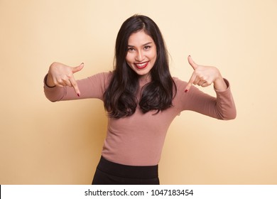 Beautiful Young Asian Woman Point Down To Blank Space On Beige Background