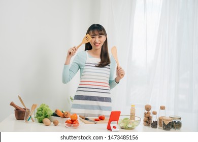 Beautiful Young Asian Woman Reading Cooking Recipe Or Watching Show While Making Salad