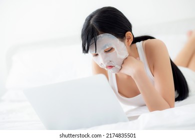 Beautiful young asian woman with sheet facial mask lying working on laptop computer on bed at bedroom, beauty girl applying face mask for skincare of wrinkle at home, skin care, health and wellness. - Shutterstock ID 2174835501