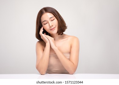 Beautiful Young Asian Woman with short hairs Holding Hands smile feeling so happy and cheerful with healthy Clean and Fresh skin,isolated on white background,Beauty Cosmetics Concept - Shutterstock ID 1571123344