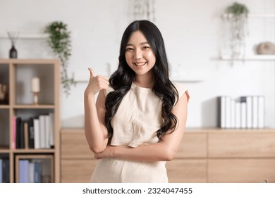 Beautiful young Asian woman showing thumbs up good gesture smile with positive emotional at home. Attractive female making finger thumbs up happiness and cheerful. Women lifestyle concept - Powered by Shutterstock