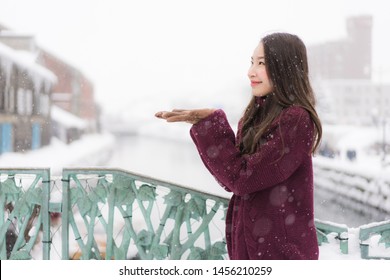 Beautiful young asian woman smile and happy with travel trip at Otaru canal Hokkaido Japan in Snow and Winter Season