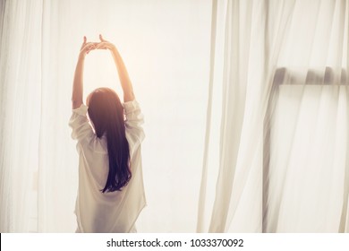 Beautiful Young Asian Woman Stretch And Relax In Bed After Wake Up Morning At Bedroom, Back View, New Day And Resting For Wellness, Lifestyle Concept.