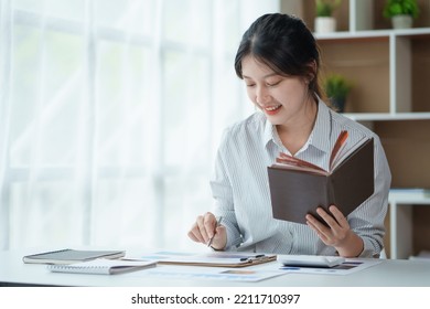 Beautiful Young Asian Woman Student Are Reading Book And Taking Notes Of Their Studies And The Details Of Their Studies In Order To Submit Reports To Teachers.