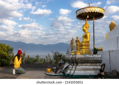 Beautiful young Asian woman traveler tourist respect and praying the old Buddha statue at Phrae, Thailand. Journey travel concept.