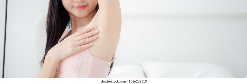 Beautiful young asian woman in underwear applying cream and lotion on armpit, beauty girl is slim happy touch skin armpit and hair removal, treatment and cosmetic and cleaning, baner website.