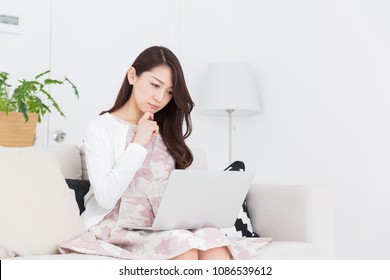 Beautiful young asian woman using laptop,think,