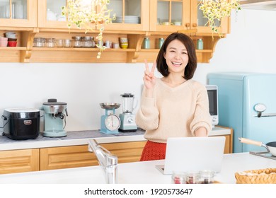 Beautiful Young Asian Woman Using Laptop,kitchen