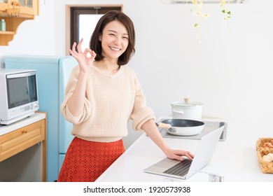 Beautiful Young Asian Woman Using Laptop,kitchen