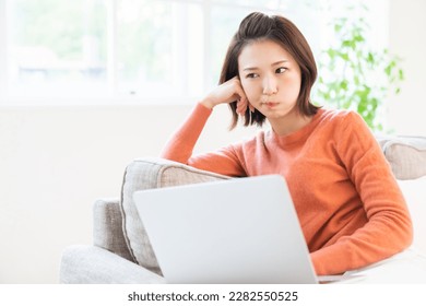 Beautiful young asian woman using laptop, think - Shutterstock ID 2282550525
