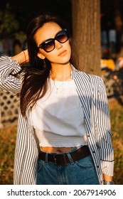 Beautiful Young Asian Woman Walking On A City Street With A White Dog. Summer Time. Outdoors.