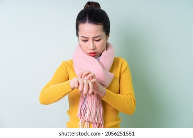 Beautiful Young Asian Woman Wearing Sweater On Green Background