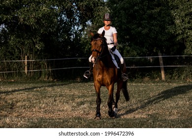 Beautiful Young Athlete In Helmet And White Sports Uniform Trains Riding On Warm Summer Evening . Active Lifestyle. Beauty And Health. Youth And Enjoyment Of Life. Role Model. Lifestyle. 