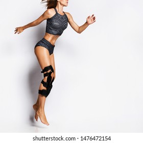 Beautiful Young Athletic Woman With A Knee Bandage Playing Sports Gymnastics Yoga, Recovery After Injury. Isolated