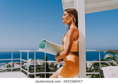 Beautiful young atlethic woman wearing sportswear doing yoga meditation on the terrace rooftop with sea view - Yoga practicer training outdoors, healthy lifestyle, sport and meditation concept - Powered by Shutterstock