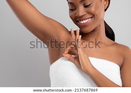 Beautiful Young Black Female Showing Her Smooth Armpit And Ok Gesture, Happy African American Woman Lifting Hand, Enjoying Underarm Depilation Result, Standing On Gray Studio Background, Copy Space