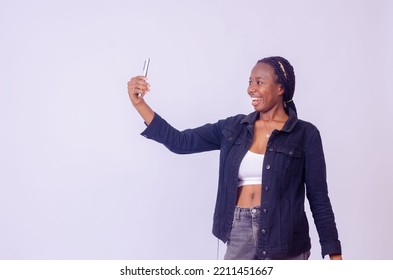 Beautiful Young Black Woman Checking Her Phone, Looks Amazed
