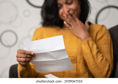 Beautiful Young Black Woman Express Surprise And Delight While Reading A Letter