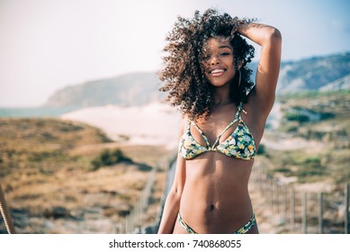 Beautiful young black woman in a wooden foot bridge at the beach