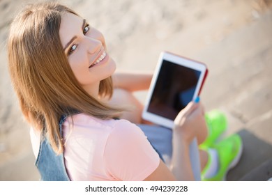 Beautiful Young Blond Female College Student Using Tablet Computer Outdoors