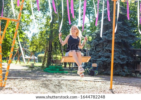 beautiful young blond woman on a swing background
