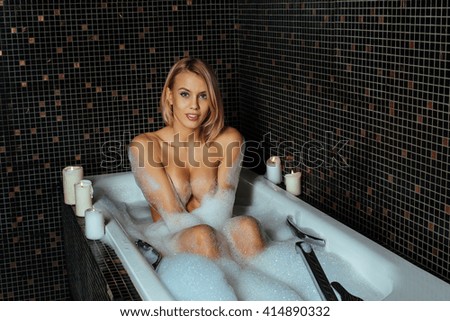 Beautiful young blond woman relaxing in a bath