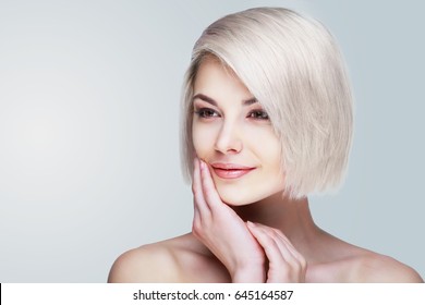 Beautiful Young Blond Woman With Short Blond Hair Against Grey Studio Background