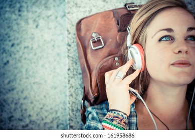 beautiful young blonde hipster woman listening music in urban landscape - Powered by Shutterstock