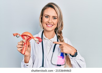 Beautiful Young Blonde Woman Holding Anatomical Model Of Female Genital Organ Smiling Happy Pointing With Hand And Finger 