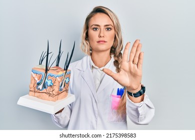 Beautiful Young Blonde Woman Holding Model Of Anatomical Skin And Hair With Open Hand Doing Stop Sign With Serious And Confident Expression, Defense Gesture 