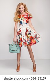 Beautiful Young Blonde Woman In Nice Spring Dress, Handbag Posing In A Studio. Fashion Spring Summer Photo