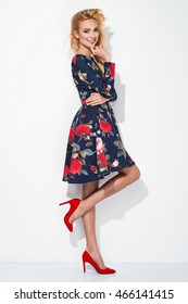 Beautiful Young Blonde Woman In Nice Long Pattern Dress, Red High Heels Posing In A Studio. Fashion Spring Summer Photo