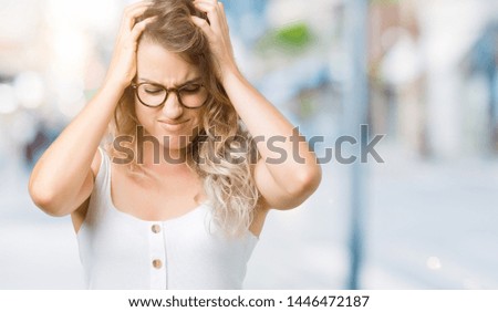 Beautiful young blonde woman wearing glasses over isolated background suffering from headache desperate and stressed because pain and migraine. Hands on head.