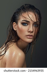 Beautiful Young Blue-eyed Woman With Wet Skin And Wet Hair In The Studio On A Gray Background. Close-up Portrait.