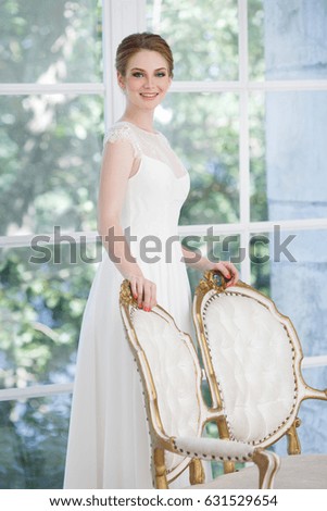 Beautiful young bride on the window background.