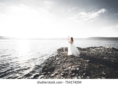 Beautiful young bride posing on the background sea.