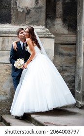 Beautiful Young Bride With Wedding Bouquet And Groom Near Old Castle Before Wedding Ceremony