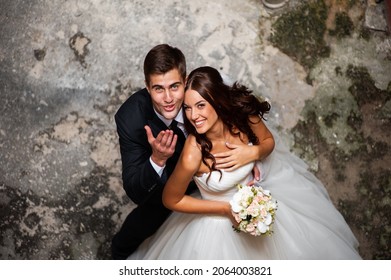 Beautiful Young Bride With Wedding Bouquet And Groom Near Old Castle Before Wedding Ceremony