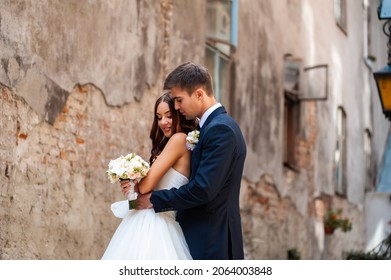 Beautiful Young Bride With Wedding Bouquet And Groom Near Old Castle Before Wedding Ceremony