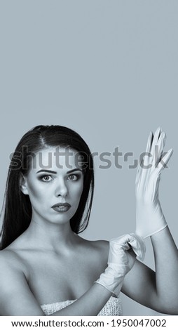 Beautiful young brunette putting on blue latex gloves aspect ratio convenient for use in stories. monochrome black and white image with blue tint.